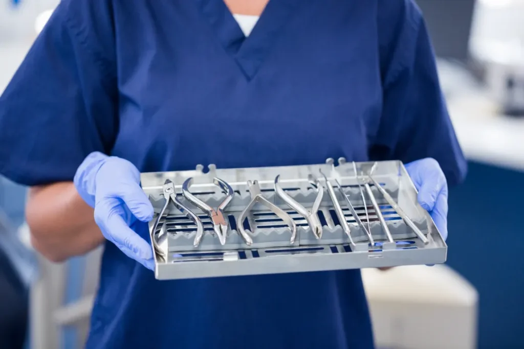 Orthodontic assistant holding a sterilized tray of orthodontic hand tools.
