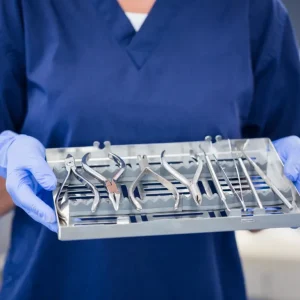 Orthodontic assistant holding a sterilized tray of orthodontic hand tools.