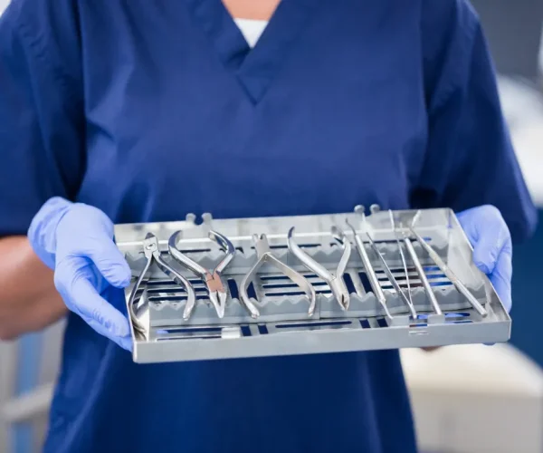 Orthodontic assistant holding a sterilized tray of orthodontic hand tools.