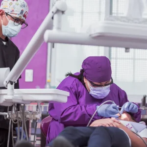 dentist and dental assistant wearing full PPE during a patient procedure.